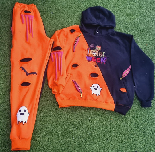 Orange and navy Halloween-themed sweatshirt and pants on a green surface
